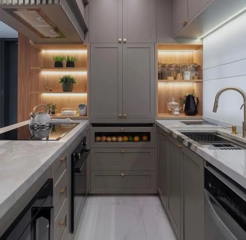 Cinza sobre mármore — Bancada de mármore em U, nichos amadeirados com fita de LED, gaveteiro frutero e ferragens douradas.